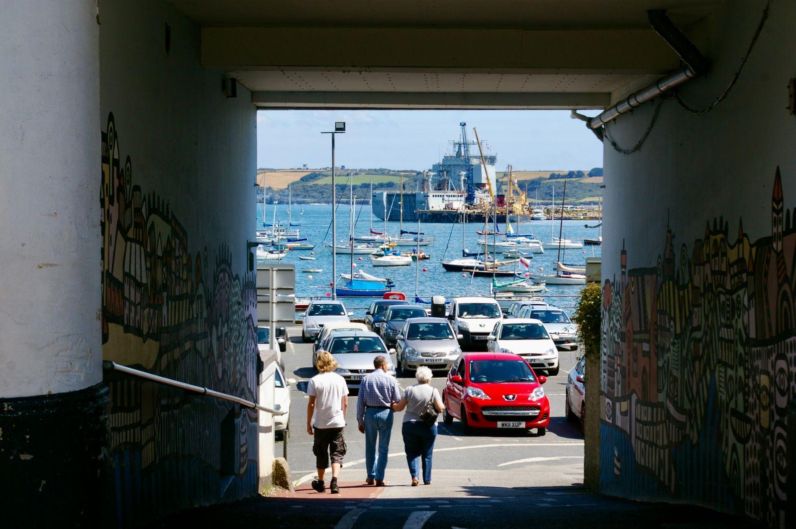 View of Falmouth harbour through a mural-painted passageway